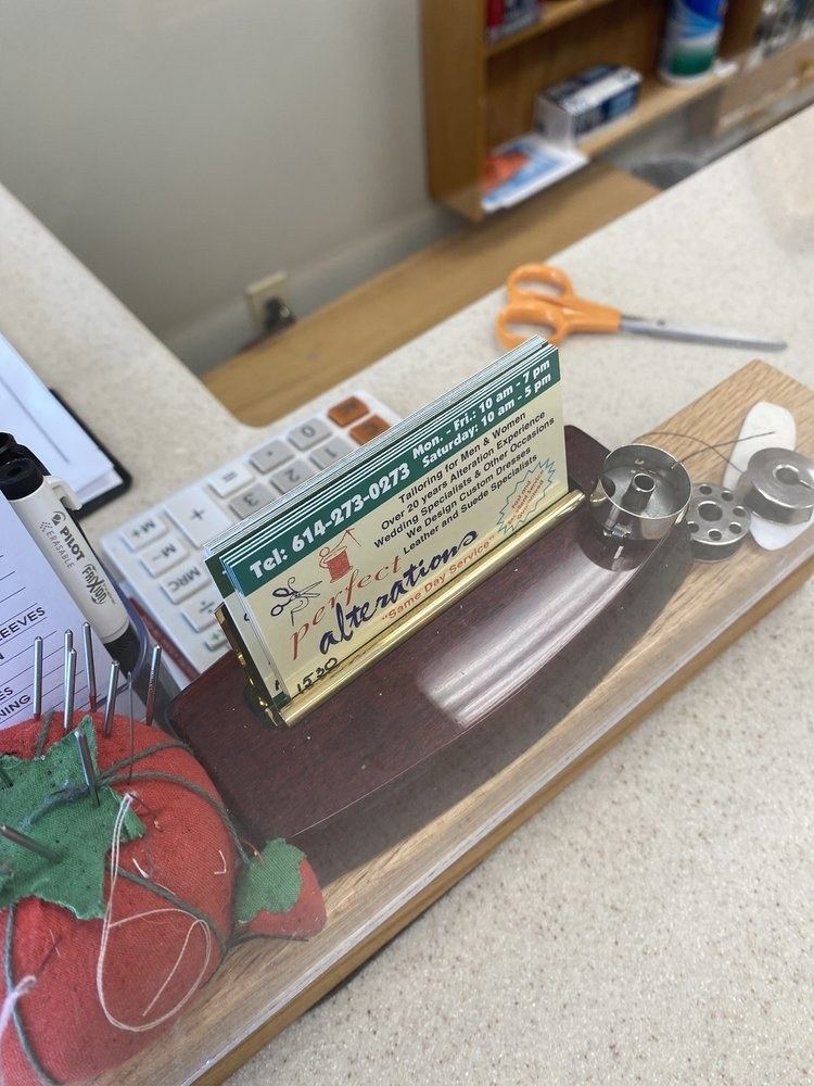 Pincushion and business card on the front counter